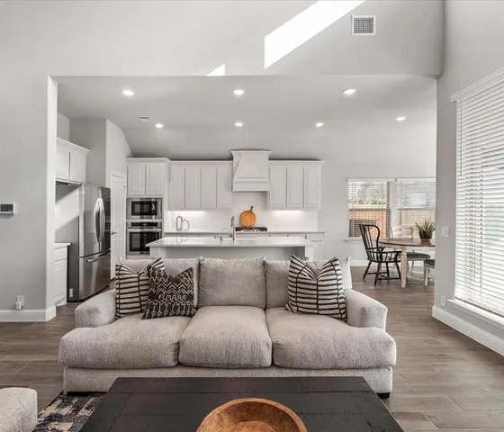 a living room with furniture and kitchen view