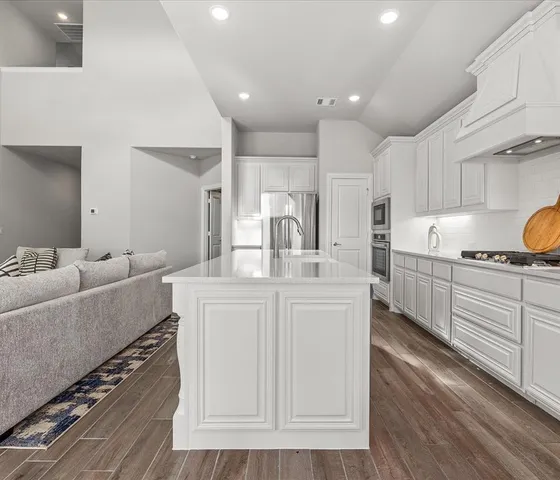 a kitchen with kitchen island white cabinets and stainless steel appliances