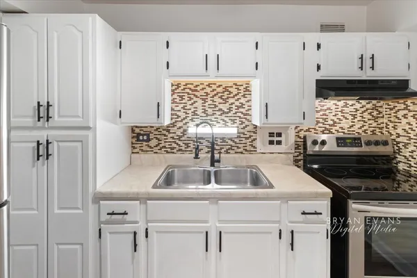 a kitchen with a sink stove and cabinets