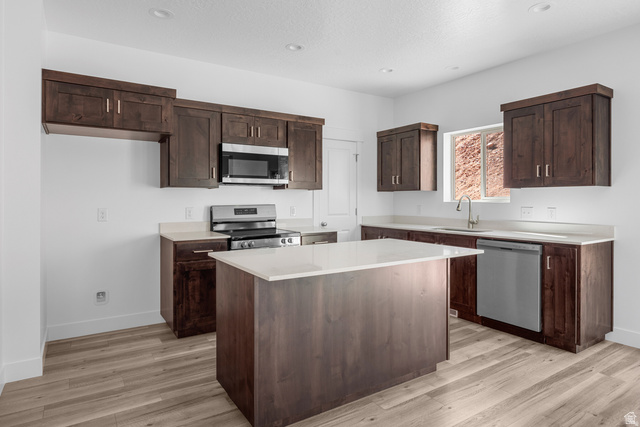 291 North Slant Road, Unit 46M Mapleton, UT 84660 - Photo 3 of 19 Kitchen with dark wood finish cabinetry, stainless steel appliances, light wood-style floors, recessed lighting, and a center island