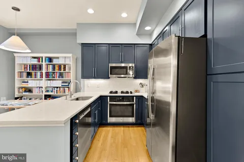 a kitchen with stainless steel appliances a stove a refrigerator and a sink