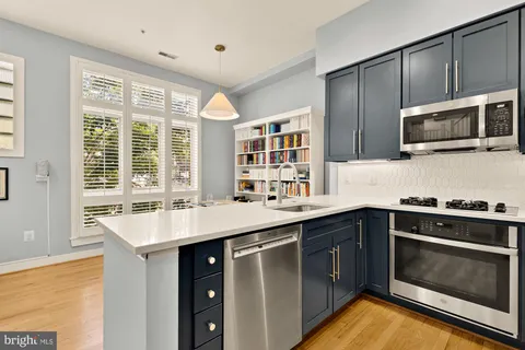 a kitchen with stainless steel appliances granite countertop a sink and stove top oven