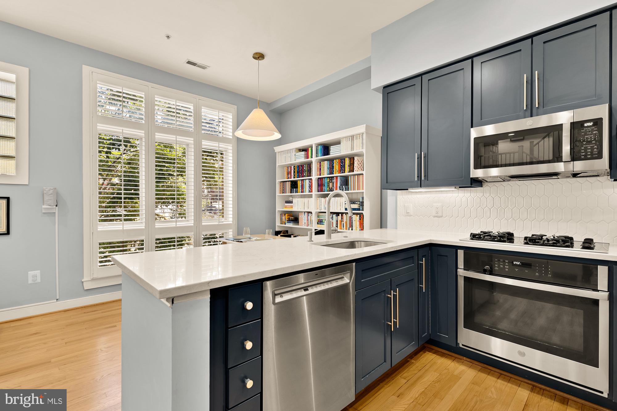 2363 Champlain Street Northwest, Unit 26 Washington, DC 20009 - Photo 14 of 35 a kitchen with stainless steel appliances granite countertop a sink and stove top oven