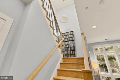a view of staircase with lots of frames on wall and a large window