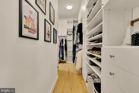 a hallway with a white cabinets and wooden floor