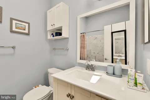 a bathroom with a sink vanity mirror and toilet