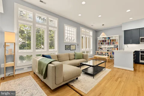 a living room with furniture a flat screen tv and a large window