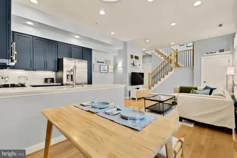 a living room with furniture kitchen view and a large window