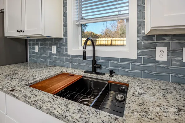 a kitchen with granite countertop a sink stove and cabinets