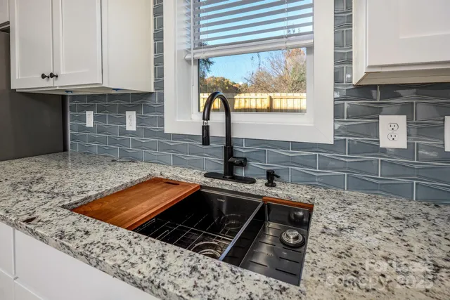 a kitchen with granite countertop a sink stove and cabinets