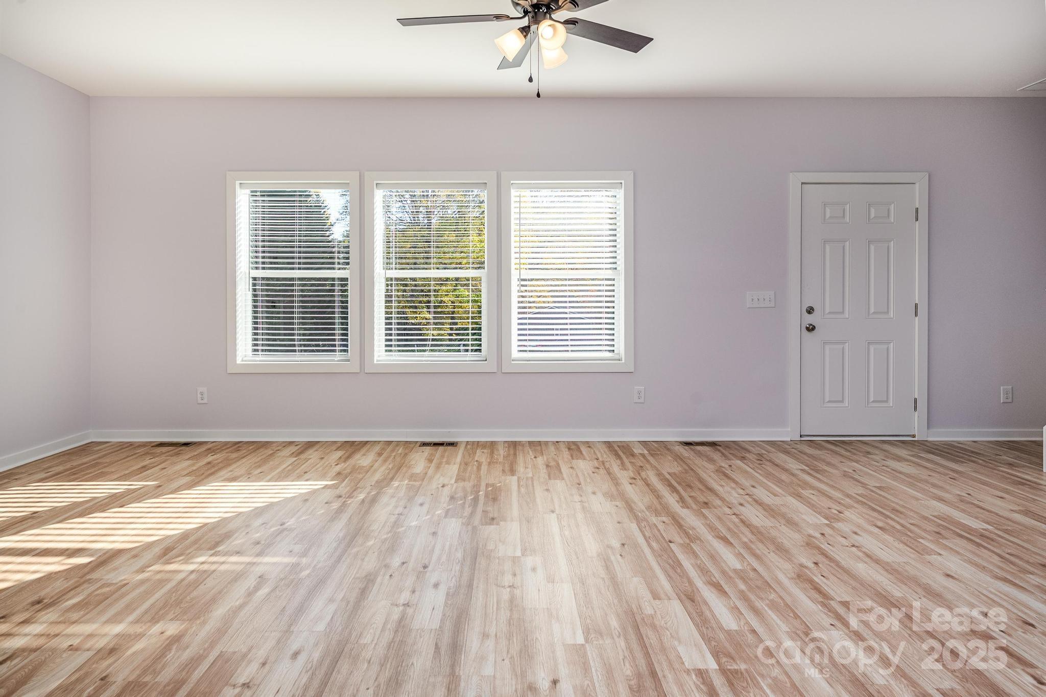 7039 Executive Circle Denver, NC 28037 - Photo 14 of 48 a view of an empty room with a window and wooden floor
