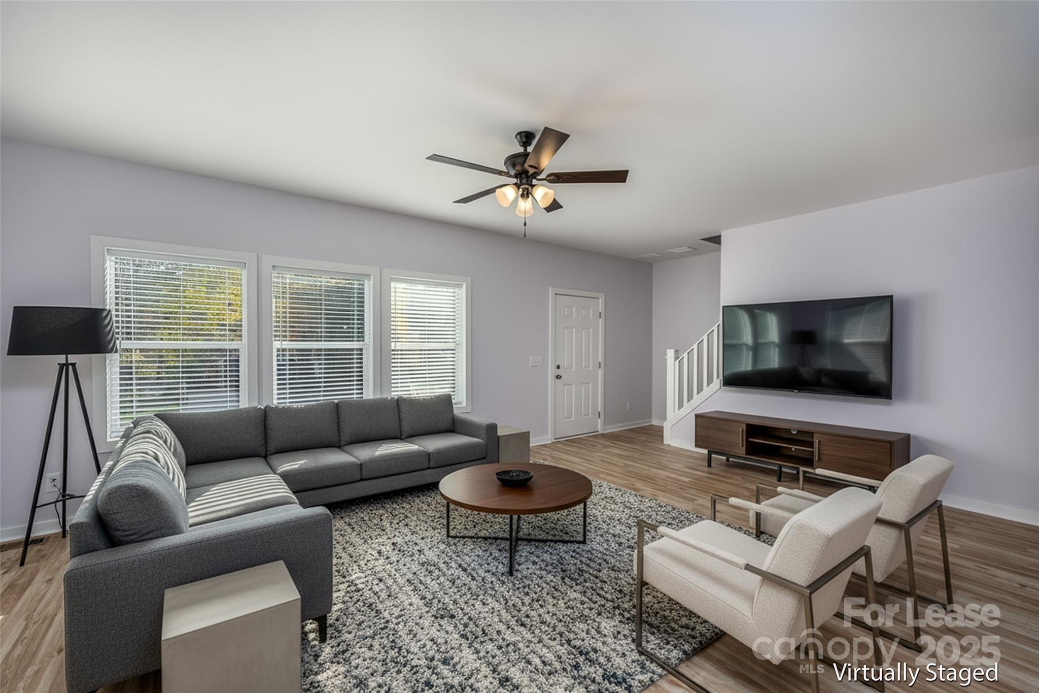 7039 Executive Circle Denver, NC 28037 - Photo 15 of 48 a living room with furniture a flat screen tv and a large window