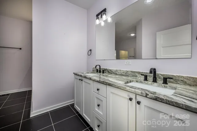 a bathroom with a granite countertop sink and a mirror