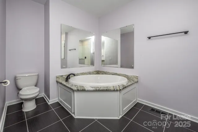 a bathroom with a granite countertop sink and a toilet