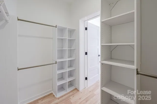 a view of walk in closet with empty racks
