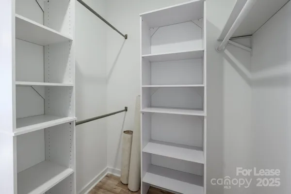 a view of walk in closet with empty racks