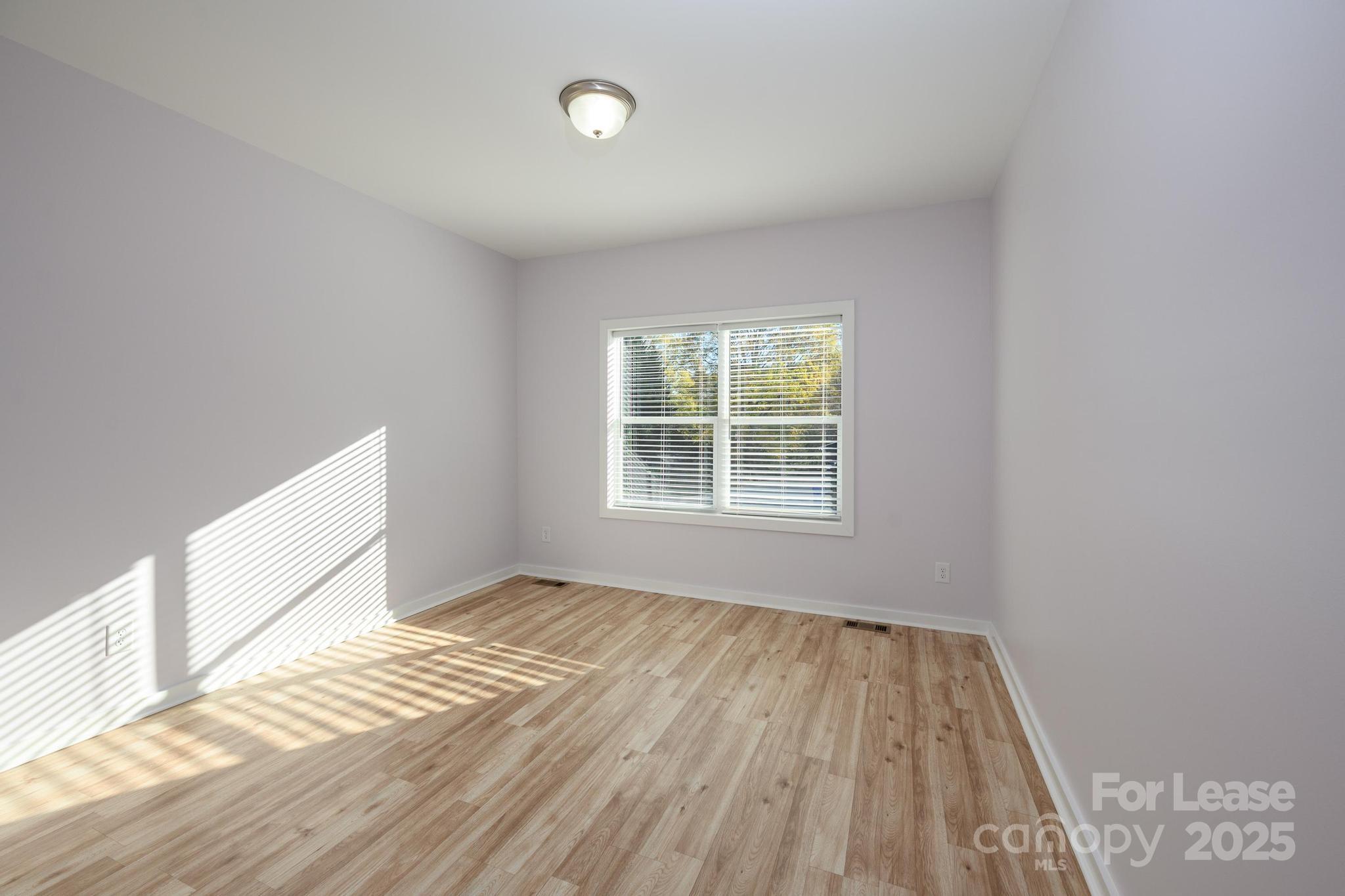 7039 Executive Circle Denver, NC 28037 - Photo 25 of 48 an empty room with wooden floor and windows