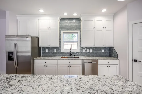 a kitchen with a sink refrigerator and cabinets