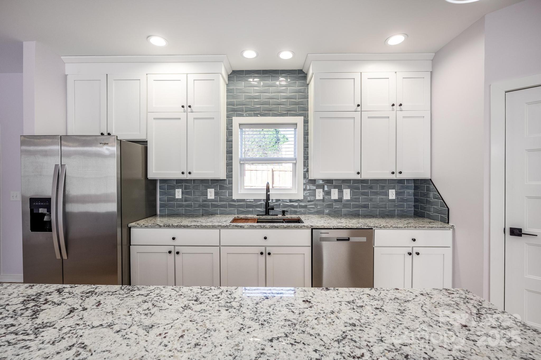 7039 Executive Circle Denver, NC 28037 - Photo 5 of 48 a kitchen with a sink refrigerator and cabinets
