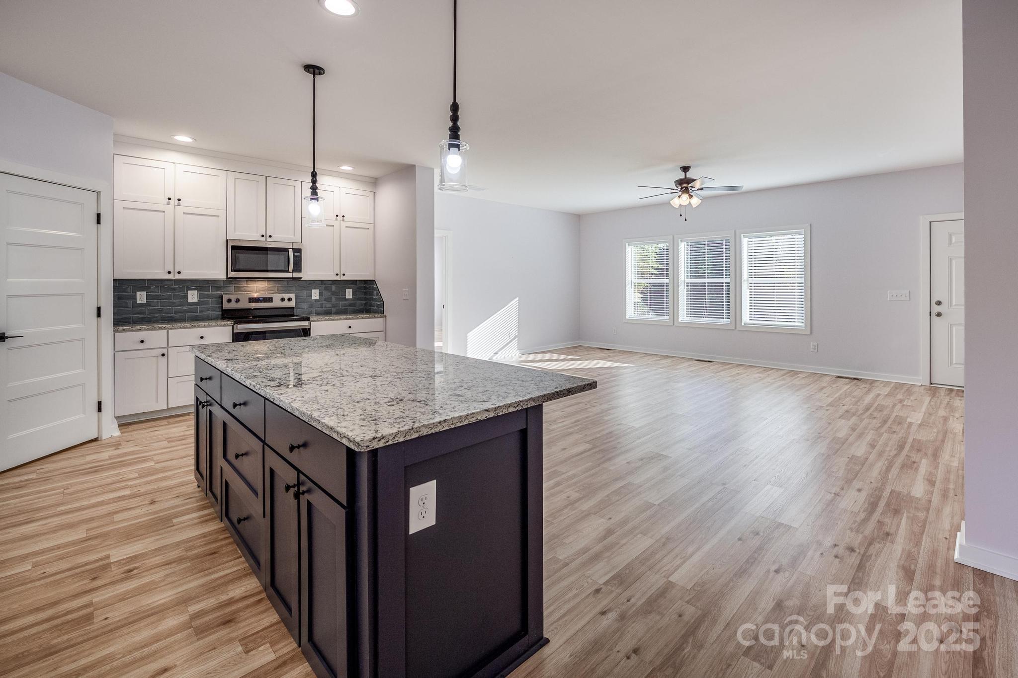 7039 Executive Circle Denver, NC 28037 - Photo 6 of 48 a kitchen with stainless steel appliances granite countertop a stove a sink dishwasher a refrigerator and a wooden floor