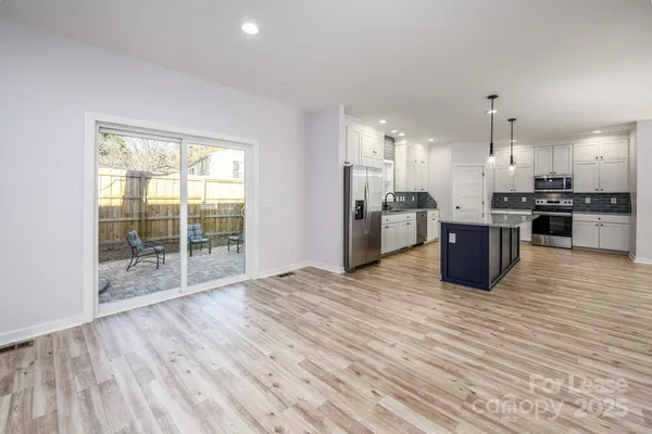 a view of kitchen with stainless steel appliances granite countertop a stove top oven and refrigerator