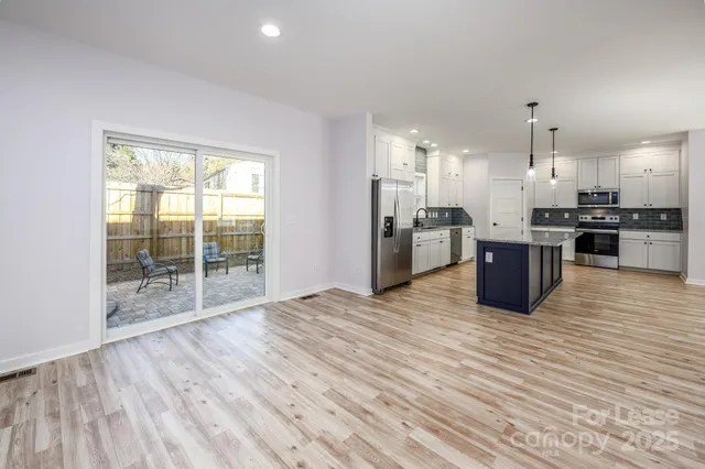 a view of kitchen with stainless steel appliances granite countertop a stove top oven and refrigerator
