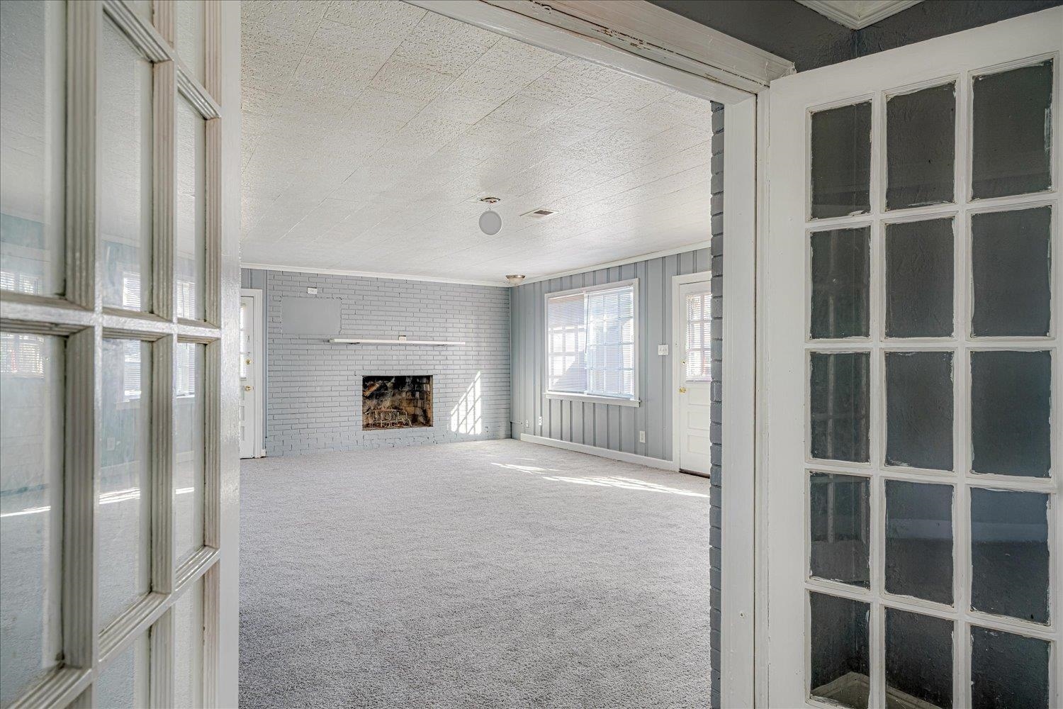 1114 Brownlee Road Memphis, TN 38116 - Photo 13 of 32 Unfurnished living room with carpet flooring, a fireplace, and ornamental molding