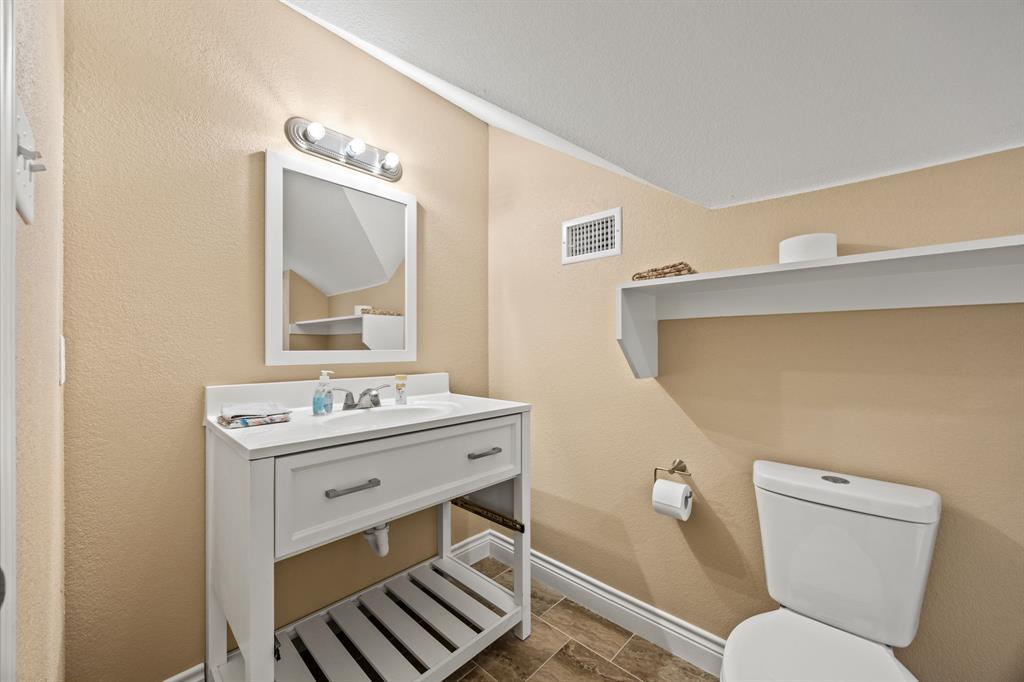 5230 Esquire Estates Road Mabank, TX 75156 - Photo 14 of 19 a bathroom with a toilet a sink and mirror