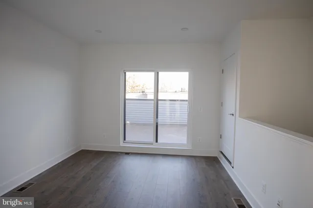 an empty room with wooden floor and sliding door