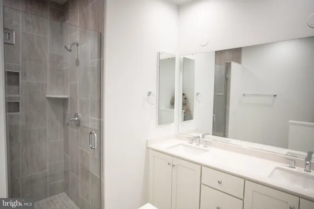 a bathroom with a double vanity sink and mirror