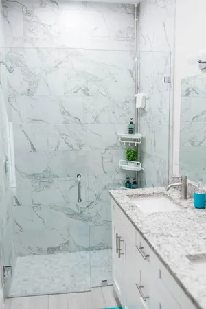 a bathroom with a granite countertop sink and white shower