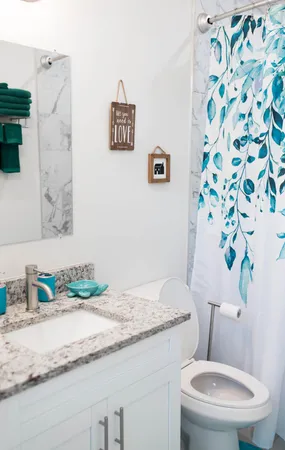 a bathroom with a granite countertop toilet and a sink