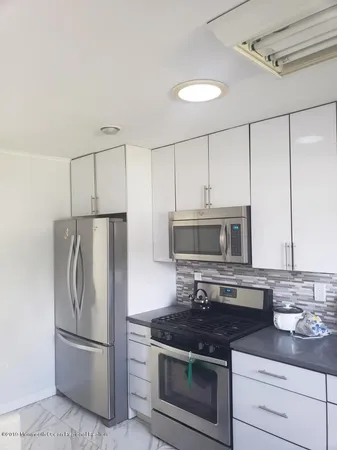 a kitchen with stainless steel appliances granite countertop a stove a refrigerator and a microwave