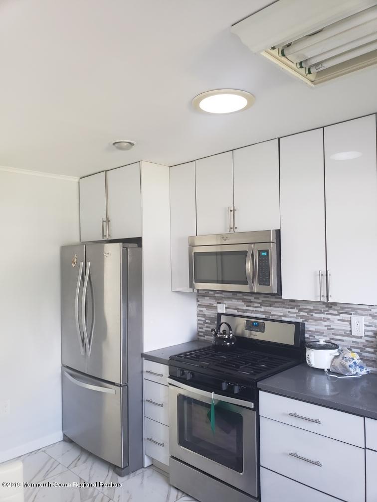 240 Castlewall Avenue Elberon, NJ 07740 - Photo 3 of 6 a kitchen with stainless steel appliances granite countertop a stove a refrigerator and a microwave