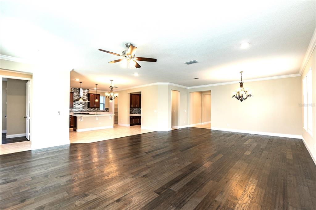 8278 Procida Isle Lane Windermere, FL 34786 - Photo 24 of 90 a view of an empty room with wooden floor and a ceiling fan