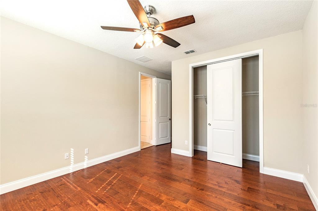 8278 Procida Isle Lane Windermere, FL 34786 - Photo 67 of 90 an empty room with wooden floor and a ceiling fan