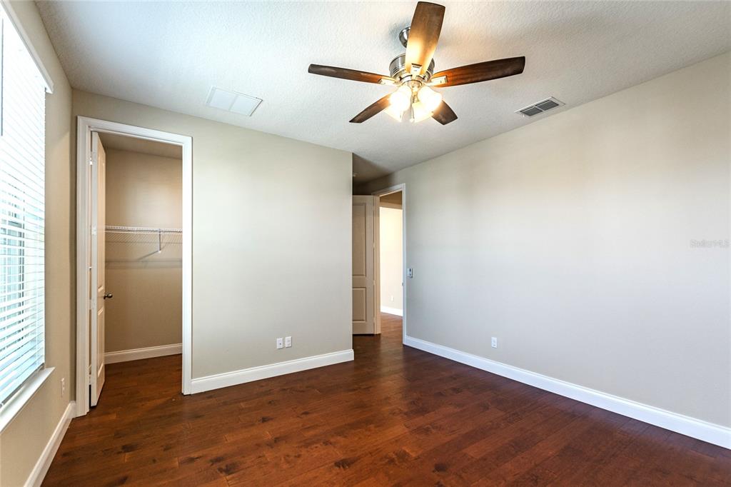 8278 Procida Isle Lane Windermere, FL 34786 - Photo 79 of 90 an empty room with wooden floor fan and windows