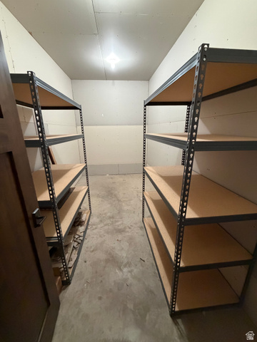 4536 North 475 East Provo, UT 84604 - Photo 28 of 65 Dedicated storage area featuring two multi-level shelving units, concrete flooring, and an overhead light fixture