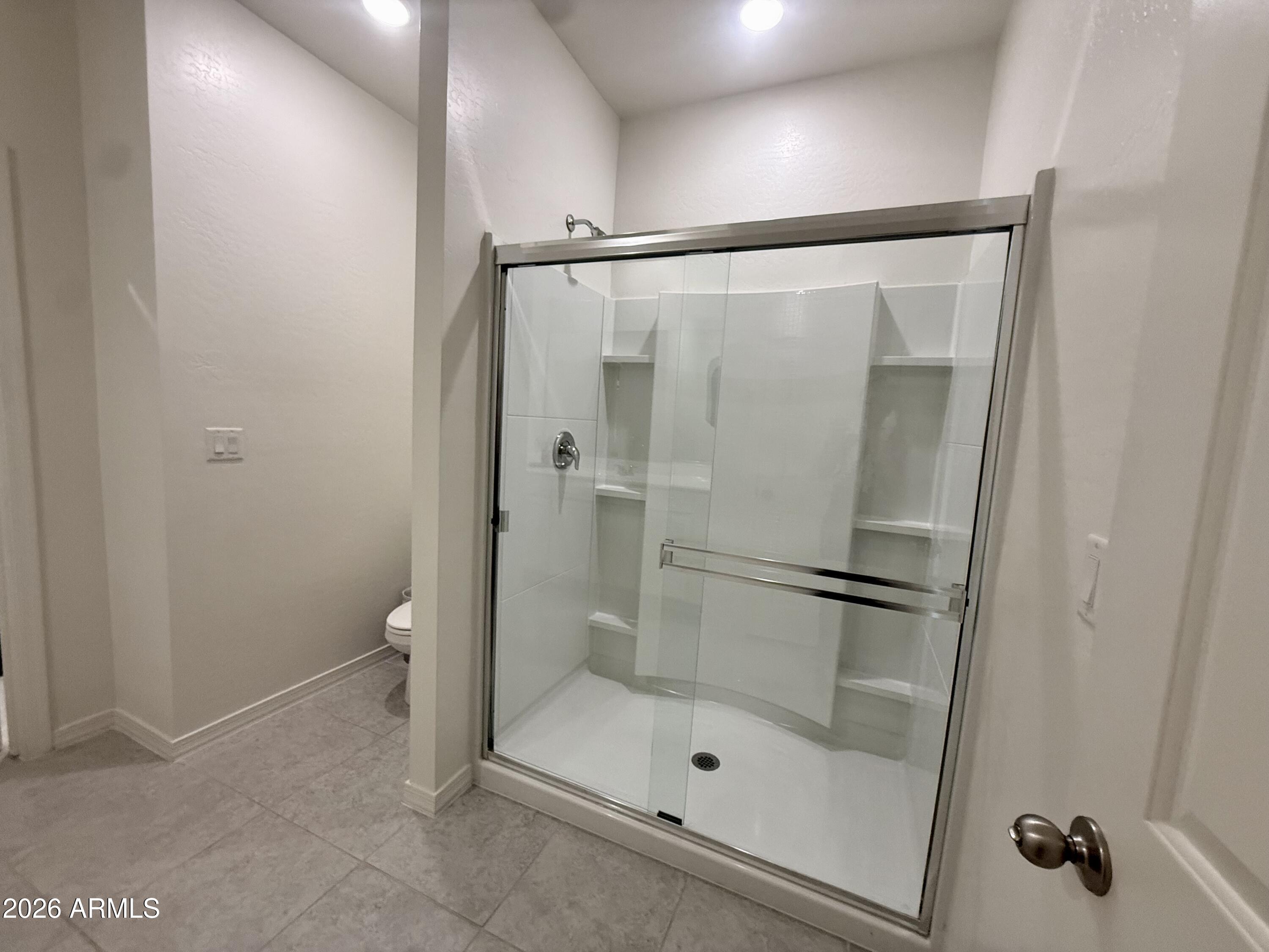 25839 North Boreas Road Florence, AZ 85132 - Photo 11 of 20 a bathroom with a glass shower door and a toilet