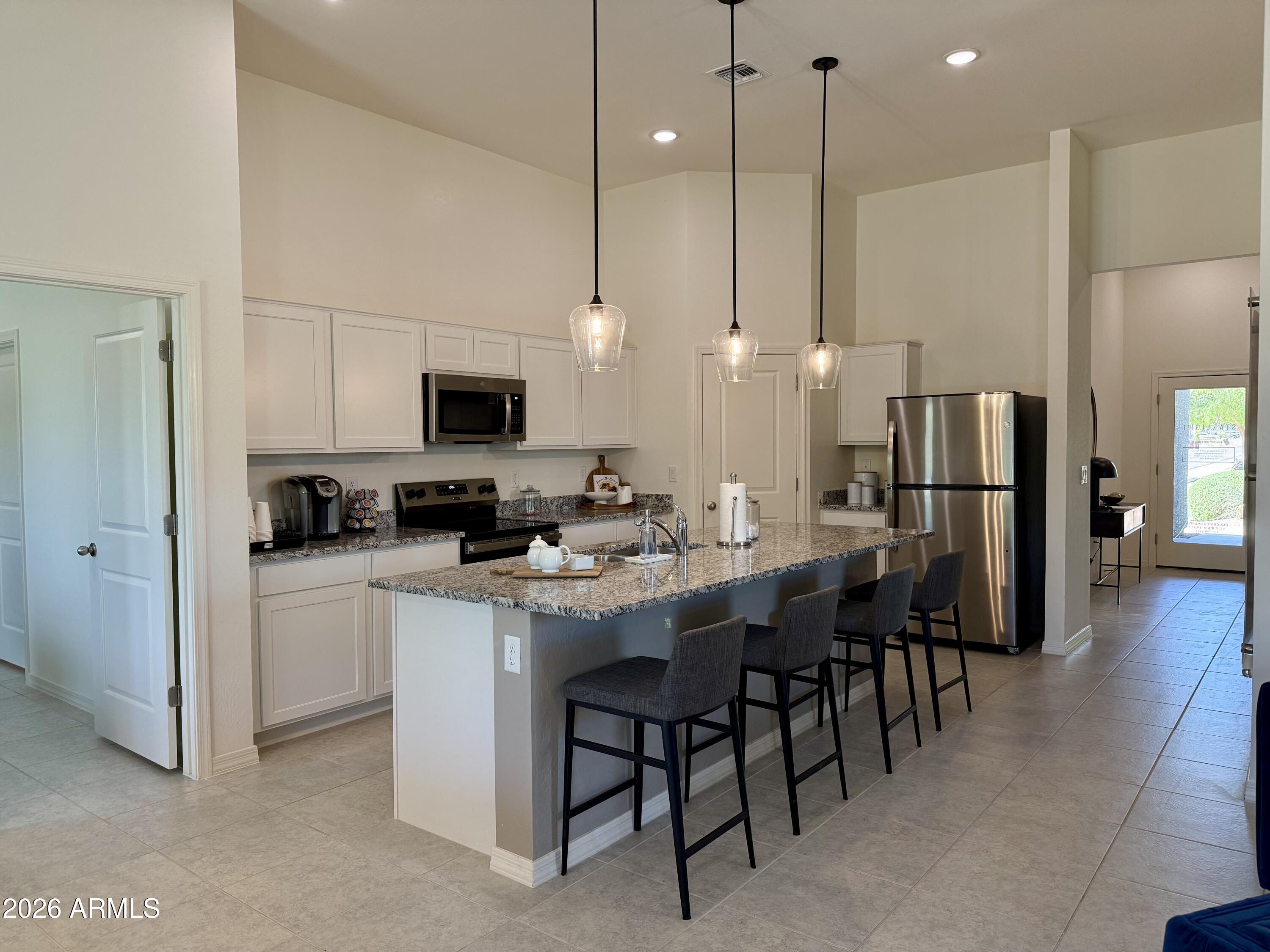25839 North Boreas Road Florence, AZ 85132 - Photo 2 of 20 a kitchen with stainless steel appliances kitchen island a table chairs and a refrigerator