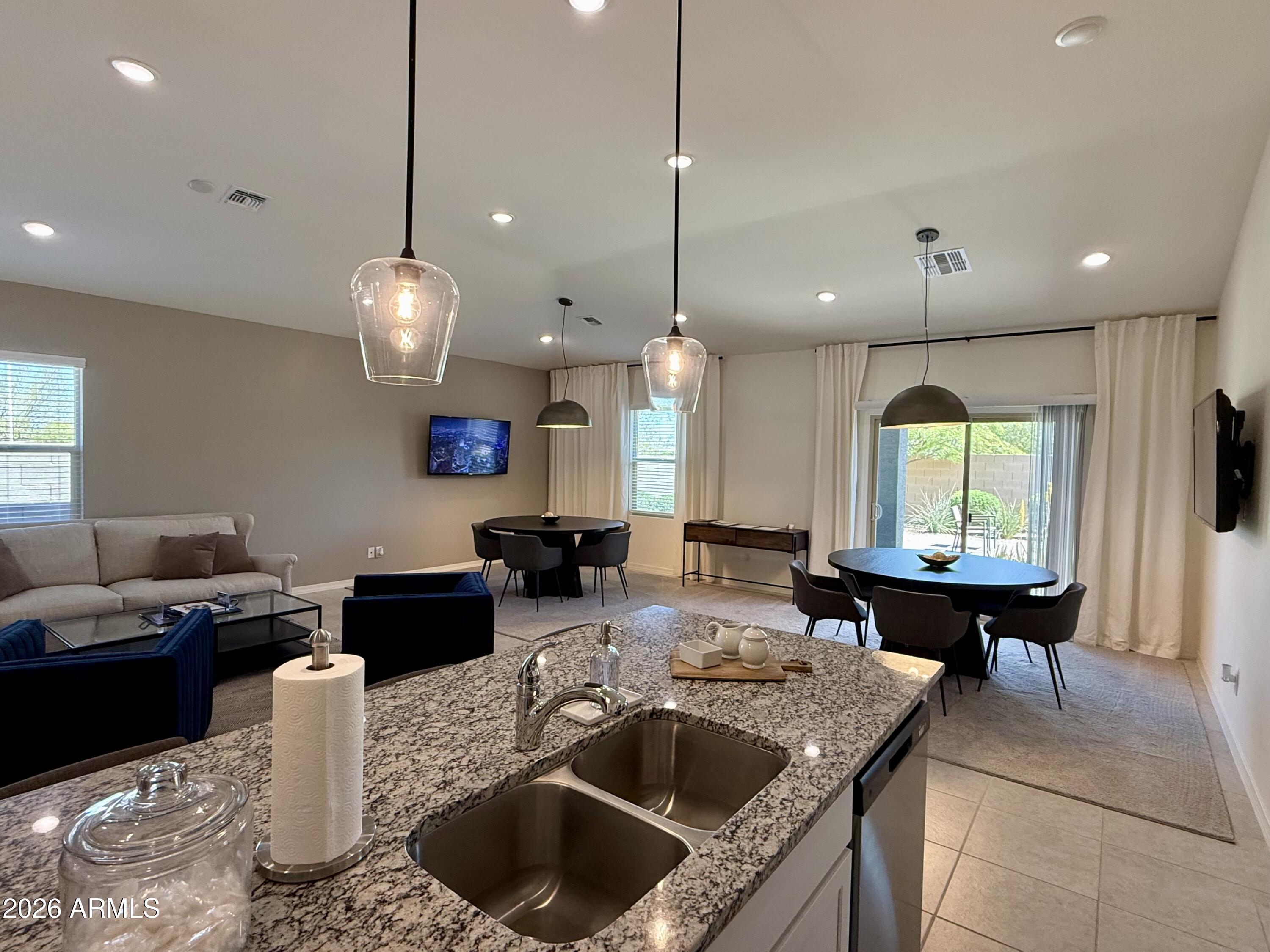 25839 North Boreas Road Florence, AZ 85132 - Photo 3 of 20 a kitchen with a stove a sink a counter space and living room view