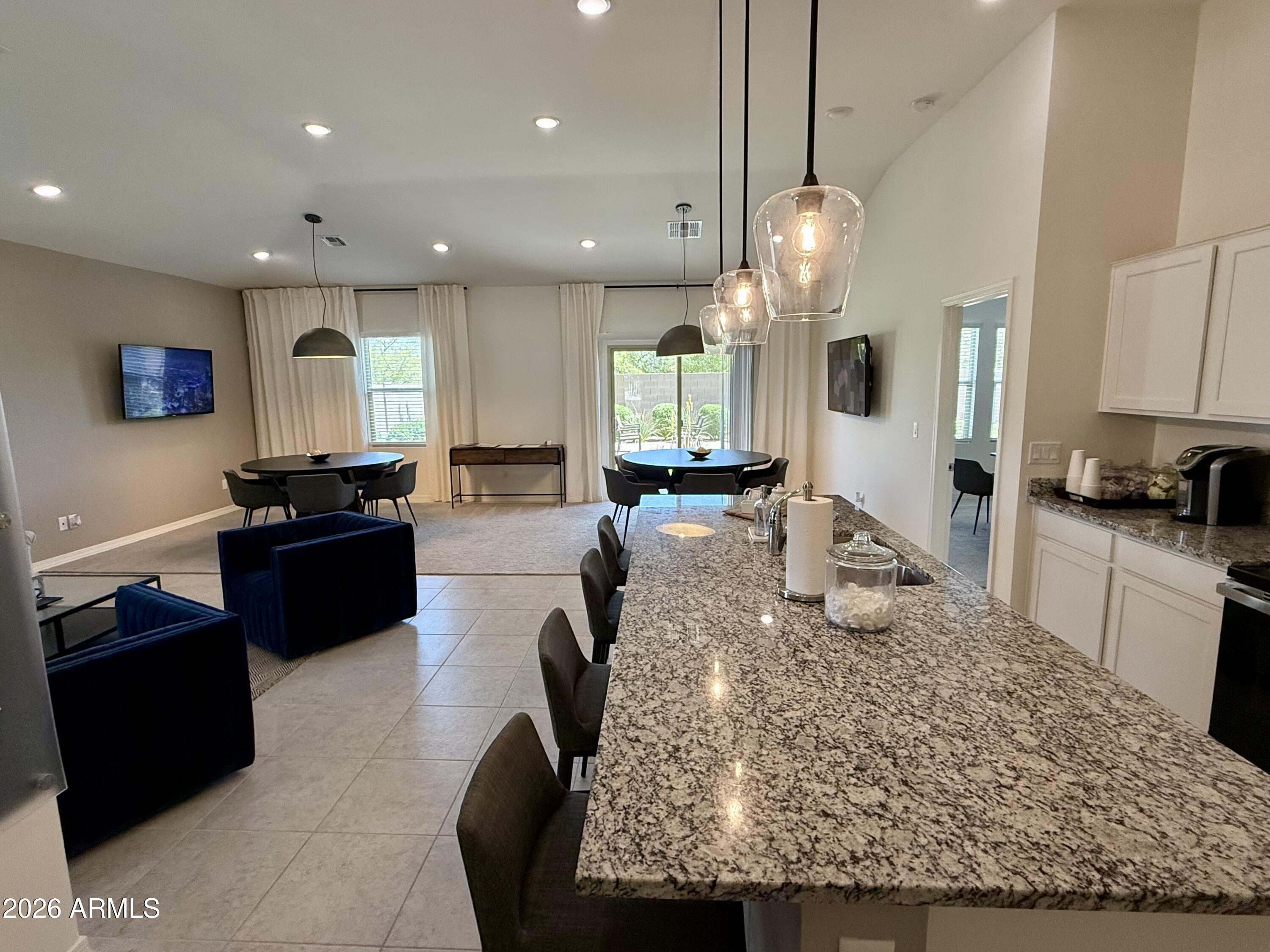 25839 North Boreas Road Florence, AZ 85132 - Photo 8 of 20 an open kitchen with granite countertop kitchen island stainless steel appliances a stove a sink a oven a dining table and chairs