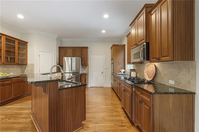 a kitchen with stainless steel appliances granite countertop a sink stove and refrigerator
