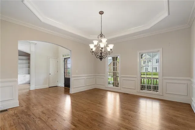 a view of a livingroom with wooden floor and a chandelier