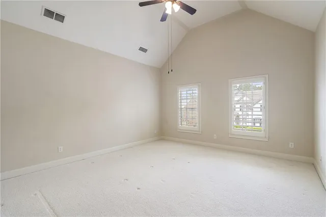 an empty room with a window and a ceiling fan