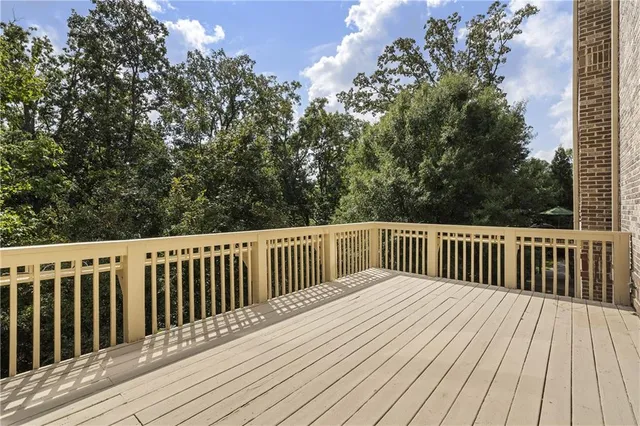 a balcony with wooden floor and trees