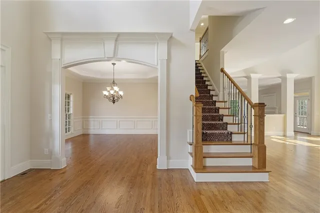 a view of a hallway with wooden floor and stairs