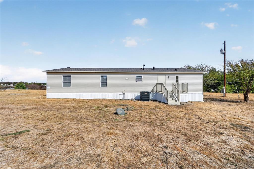 246 PR-4443 Rhome, TX 76078 - Photo 28 of 35 Manufactured residence with light gray siding, dark shingle roof, and white skirting