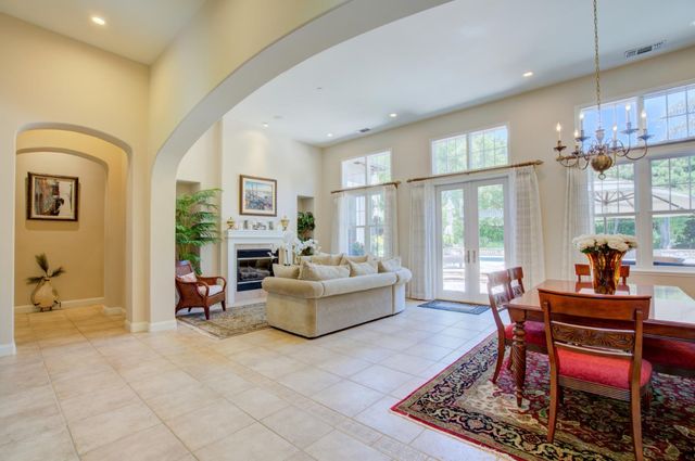 a living room with fireplace furniture and a floor to ceiling window