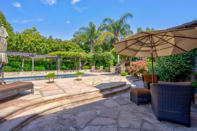 a view of a patio with a table and chairs under an umbrella